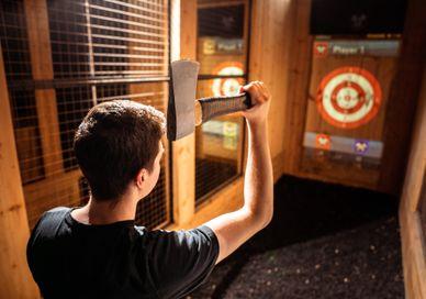 An image of a man shooting a target, One Hour Of Interactive Axe Throwing. Game of Throwing
