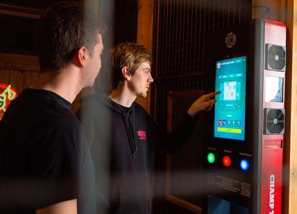 An image of a man using a vending machine, One Hour UV Glow Axe Throwing. Game of Throwing