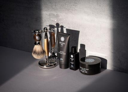 An image of a bathroom set with a shaving brush, Restorative Hot Stone Massage for Him. Gentlemen's Tonic