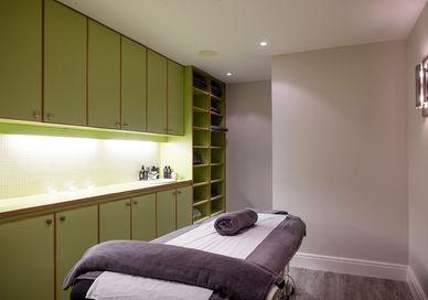 An image of a massage room with a towel, Restorative Hot Stone Massage for Him. Gentlemen's Tonic