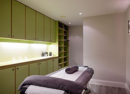 An image of a massage room with a towel, Restorative Hot Stone Massage for Him. Gentlemen's Tonic