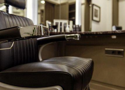 An image of a barber chair in a salon, Traditional Haircut, Wet Shave & Prep Facial. Gentlemen's Tonic