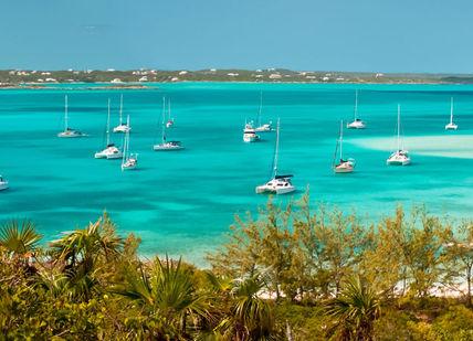 An image of a beach with boats in the water, Luxury Sailing Yacht Charter in the Bahamas. Getaway-Pseudo-Supplier