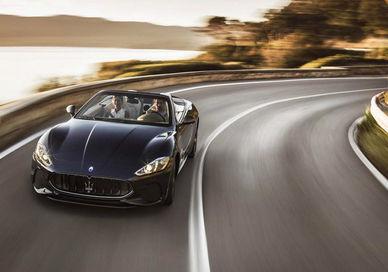 An image of a blue car driving down a road, One Day Hire of Maserati GranCabrio.