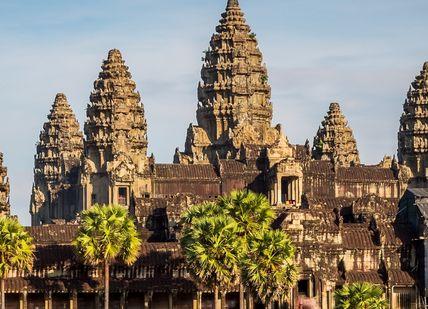 An image of a large building with palm trees, Private Seven-Day Tour of Angkor Wat, Phnom Kulen & Lake Tonle Sap.