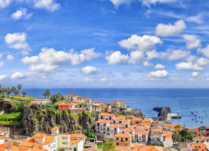 An image of a town with red roofs and blue sky, Three nights at a 5-star hotel in Funchal.