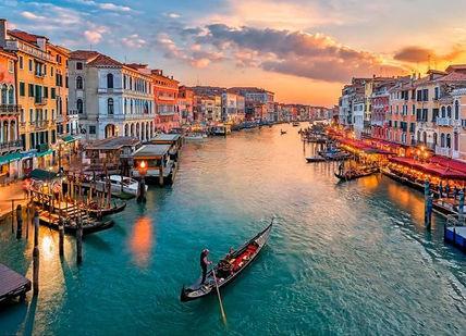 An image of a canal at sunset, Transfers to the restaurants and gondola tour in Venice.