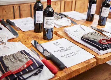An image of a table with wine bottles and napkins, Butchery Course. Hampstead Butcher
