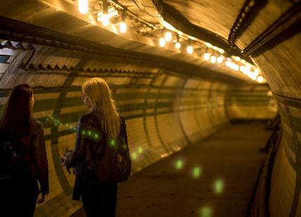 An image of a woman walking in a tunnel, Private Secret Underground Tour. Hidden London