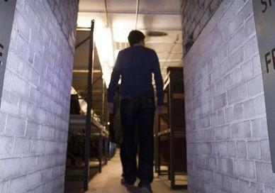 An image of a man walking down a hallway, Secret Underground Tour of Clapham South Station. Hidden London