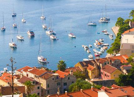 An image of a harbor with boats in the water, Discover Croatian Gastronomy on the trails of Anthony Bourdain. Hotel Boskinac