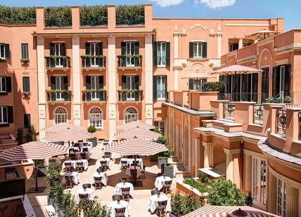 An image of a courtyard with tables and umbrellas, Three Night stay. Hotel de la Ville