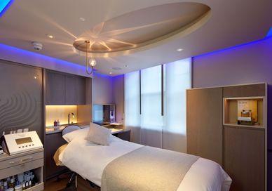 An image of a bedroom with a bed and a desk, Hot Stone Massage. House of Elemis