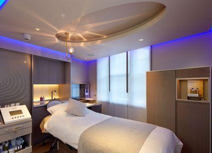 An image of a bedroom with a bed and a desk, Hot Stone Massage. House of Elemis