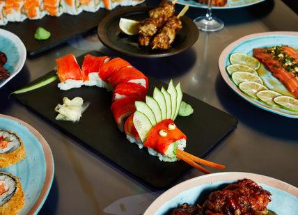 An image of a table with plates of food, Comedy Night and Dinner. inamo Restaurants