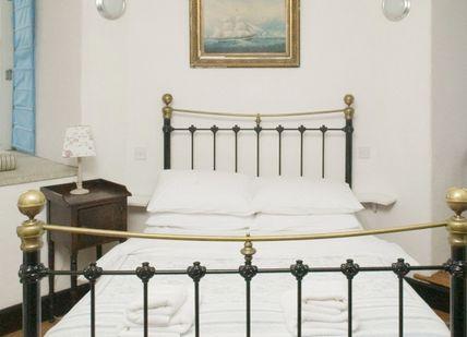 An image of a bedroom with a bed and a window, Lighthouse Break with Classic Car. Irish Landmark Trust