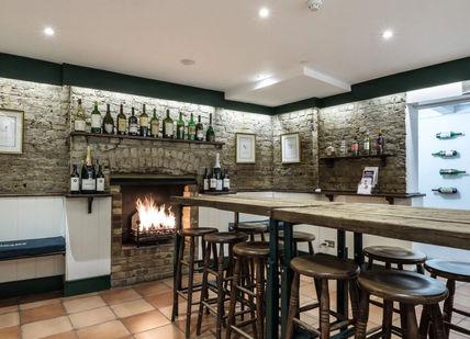 An image of a bar with a fire place, Pont Street, London. Jeroboams