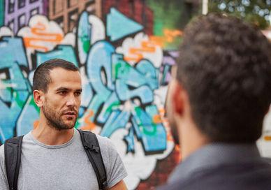 An image of a man talking to another man, Discover Street Art on a Tour. Karim Samuels - Insider