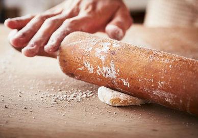 An image of a person rolling dough on a table, La Nina Cooking School. La Nina Cooking School 