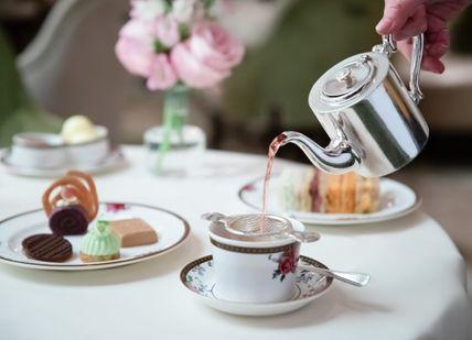 An image of a person pouring tea into a cup, Afternoon Tea. The Langham, Palm Court