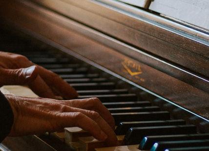 An image of a person playing a piano, Five Private Piano Lessons. The London Piano Institute