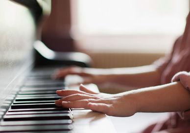 An image of a person playing a piano, Private Piano Lesson. The London Piano Institute