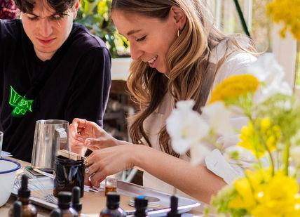 An image of a woman and a man at a table, Bespoke Branded Candle Making Class. The London Refinery