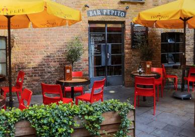 An image of a restaurant with tables and umbrellas, Pepito Camino Kings Cross. The London Wine Academy