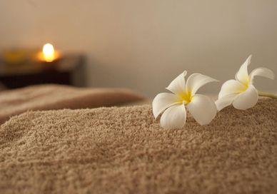 An image of a massage room with a candle, Day spa delight. Luenire