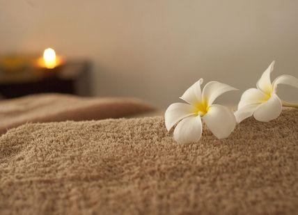 An image of a massage room with a candle, Day spa delight. Luenire