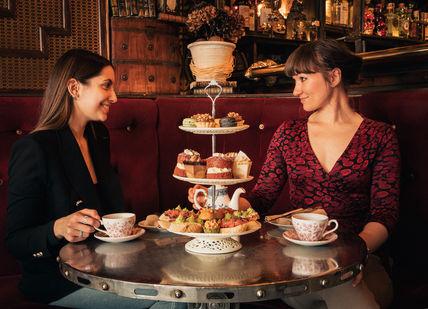 An image of two women having a meal, Bottomless Afternoon Tea. Map Maison