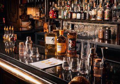 An image of a bar with alcohol bottles, Japanese Whisky Masterclass. Map Maison