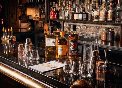 An image of a bar with alcohol bottles, Japanese Whisky Masterclass. Map Maison