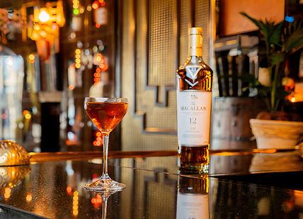 An image of a bar with a drink, Macallan Whisky Experience with Cheese Pairing and Tapas. Map Maison