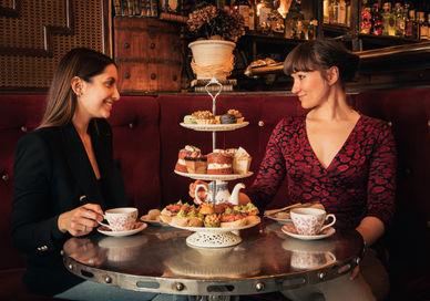 An image of two women having a meal, Map Maison Tapas-Style Afternoon Tea. Map Maison