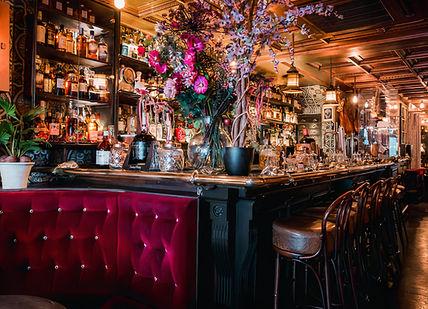 An image of a bar with a bunch of flowers, Map Maison. Map Maison
