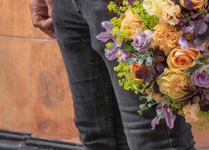 An image of a man holding a bouquet, Hand-Tied Bouquet Workshop. McQueens