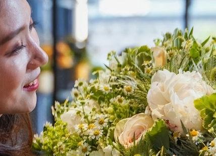 An image of a woman holding a bouquet, One-Day Flower Masterclass. McQueens