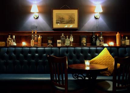 An image of a bar with a blue couch, Premium Irish Whiskey Tasting. Merchant House