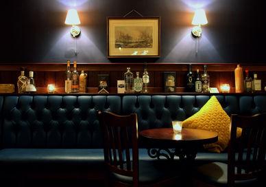 An image of a bar with a blue couch, Premium Whisky Masterclass. Merchant House