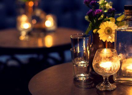 An image of a table with candles and flowers, Ultra-Premium Gin Tasting. Merchant House