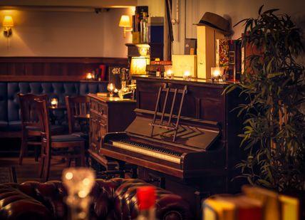 An image of a piano and a piano in a room, Ultra-Premium Gin Tasting. Merchant House