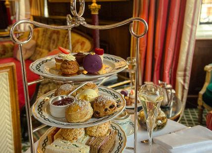 An image of a table with a tray of food, Royal Afternoon Tea. The Milestone Hotel