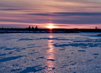 An image of the sun setting over a frozen lake, Total Northern Immersion. Natural Habitat Adventures