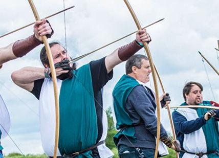 An image of a group of people holding flags, Immersive Archery Experience. Now Strike Archery