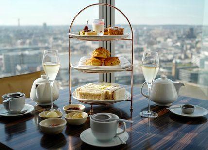 An image of a table with a cake and cups, Champagne Afternoon Tea. Oblix