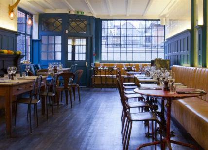 An image of a restaurant with many tables, British craft beer tasting and bar snacks. Parlour