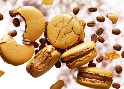 An image of a bunch of macaron falling from a white background, Bespoke Macaron Flavour Development. Pierre Hermé