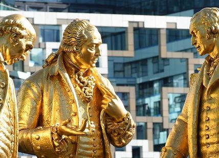 An image of two golden statues in front of a building, Private Birmingham Walking Tour. Positively Birmingham Walking Tours