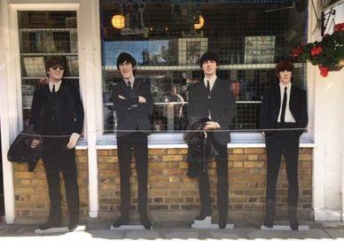 An image of three men in suits standing outside a shop, Half Day Rock Music Tour. Premium Tours